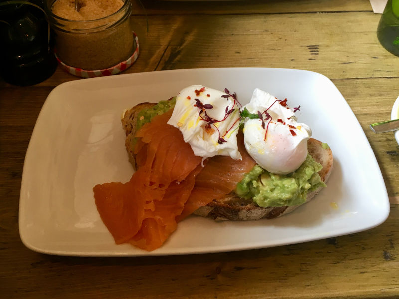 Smashed avocado with poached eggs on toasted sourdough bread from Brickwood Streatham